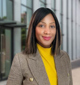 Janessa Mondestin standing in front a building wearing suit